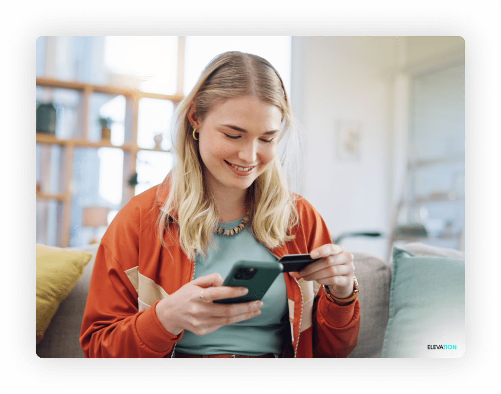 Female holding credit card and mobile device