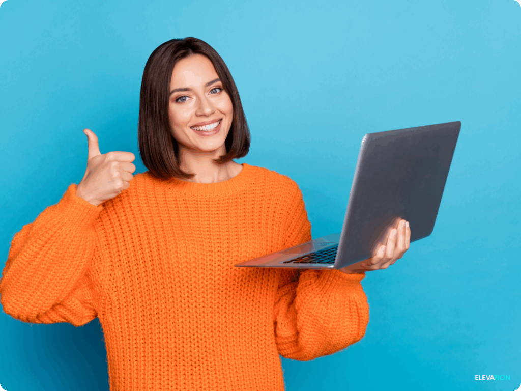 Young woman holding a laptop and giving a thumbs up gesture